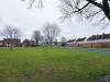 Later housing built on a green, with children playing on the road